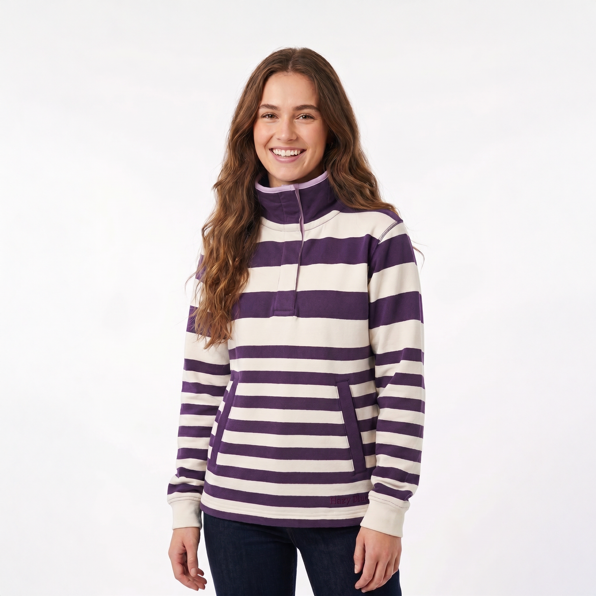 A woman modeling a purple and cream horizontally striped quarter-zip pullover sweatshirt against a plain white studio background.