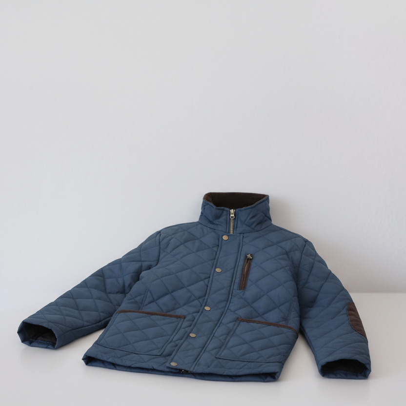Blue quilted jacket on a white surface with a white background