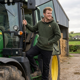 Man standing next to a tractor on a farm