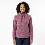 A woman with curly dark hair wearing a heathered mauve-purple full-zip fleece jacket and dark blue jeans, standing against a plain white studio background.