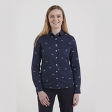 A woman modeling a navy blue long-sleeve button-up shirt with a small white butterfly pattern, paired with dark pants, against a plain light gray background.