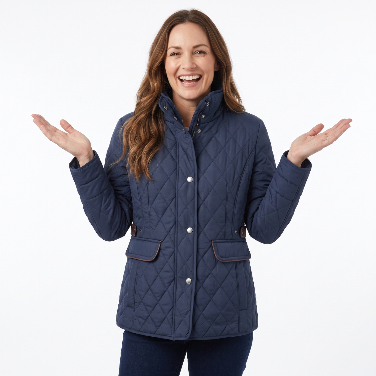 A woman modeling a navy blue quilted jacket with brown trim and silver snap buttons, posing with her hands out against a white studio background.