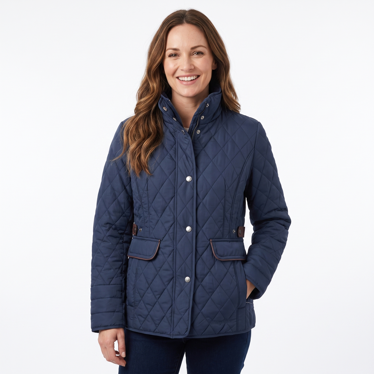 A woman wearing a navy blue diamond-quilted jacket with brown trim and silver snap buttons, standing against a plain white studio background.