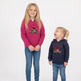 Two children modeling hoodies with tractor graphics. The taller girl wears a magenta hoodie and the shorter boy wears a navy hoodie, both paired with blue jeans and white sneakers, standing against a white studio background.