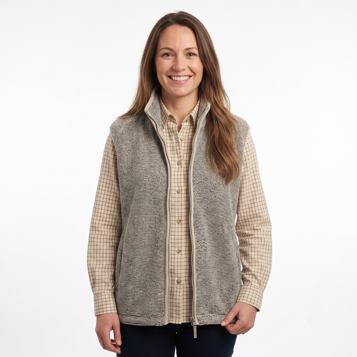 A woman modeling a gray zip-up fleece vest over a beige and brown checkered button-down shirt, photographed against a plain white studio background.