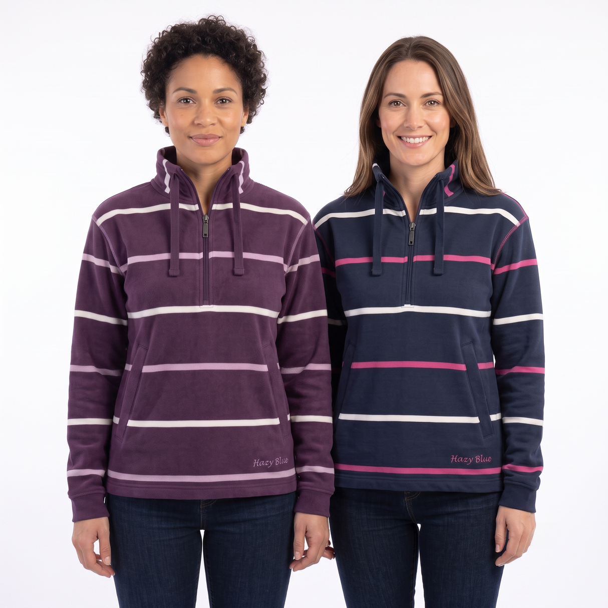 Two women modeling striped quarter-zip hooded sweatshirts against a plain white studio background. The woman on the left wears a plum purple hoodie with white and light pink horizontal stripes, and the woman on the right wears a navy blue hoodie with white and pink horizontal stripes.