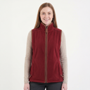 Woman wearing a red vest over a beige long-sleeve shirt on a white background