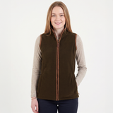 Woman wearing a brown vest over a beige long-sleeve shirt on a white background