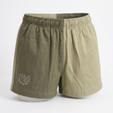 A pair of men's shorts in a two-tone olive and khaki color-blocked design, featuring an elastic waistband and a small embroidered monogram logo on the left leg.